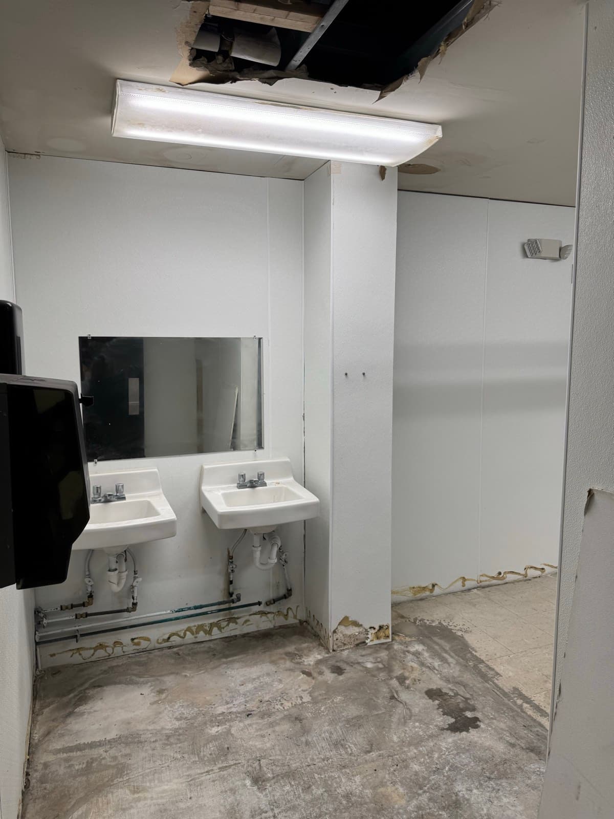 Commercial restroom stripped to the studs mid-demolition
